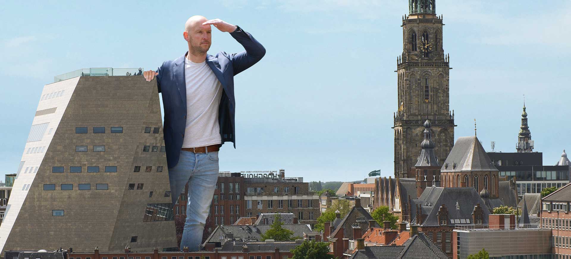 Man staat naast forum in Groningen en kijkt in de verte